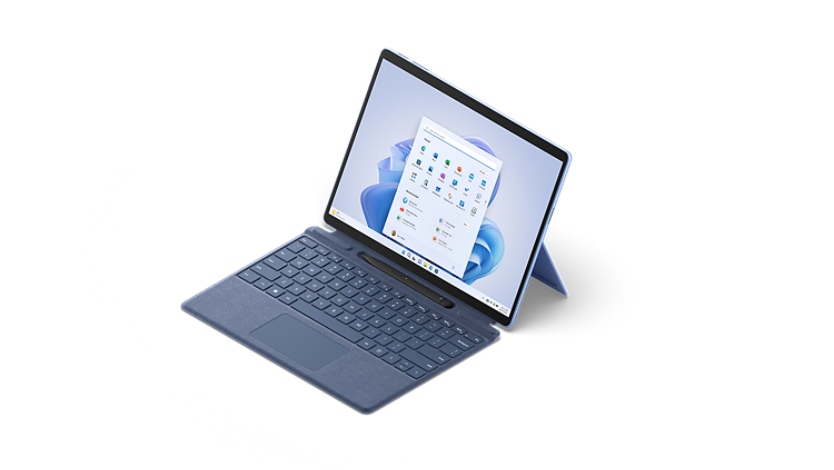 Surface Pro 9 shown from a 3/4 view with attached type cover and Surface Slim Pen 2.