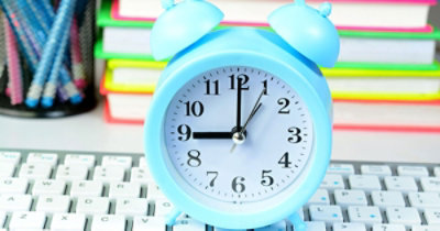 A blue alarm clock on a keyboard