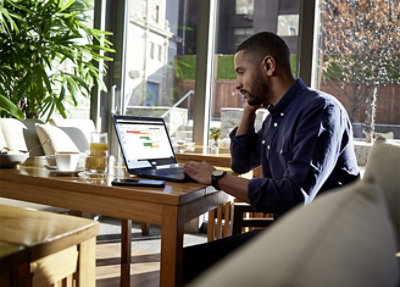 Homme travaillant sur un ordinateur portable à une table.