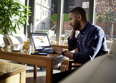 A man sitting at a desk using a laptop.