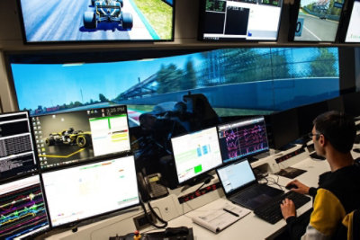 Personne travaillant sur un ordinateur portable avec plusieurs moniteurs ouverts