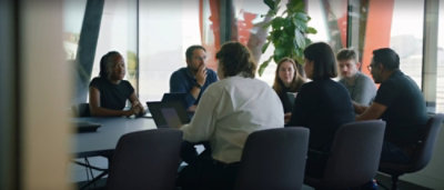People seated around a conference table collaborating in a modern meeting room.