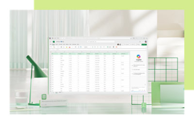 Un écran d’ordinateur affichant un tableur, entouré de fournitures de bureau aux couleurs vertes et blanches.