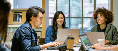 A group of people discussing something in a office room with smiling face