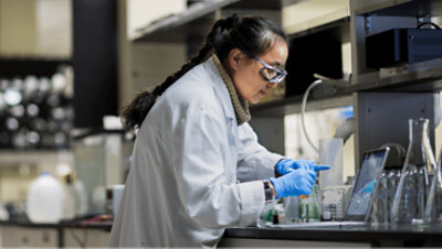 Ein Gesundheitsexperte, der in einem Lab auf einem Laptop arbeitet.