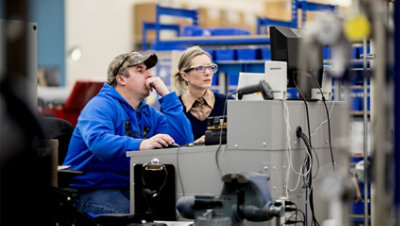 Zwei Personen in einem Lager arbeiten gemeinsam an einem Computer