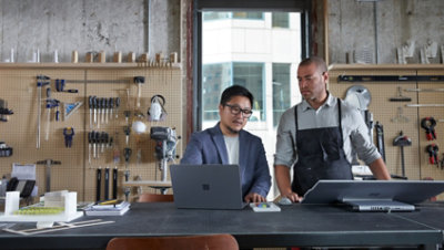 Zwei Personen in einem Workshop, die einen Laptop betrachten