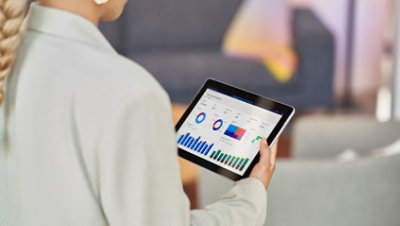 Uma pessoa a segurar um tablet a apresentar dados em gráficos