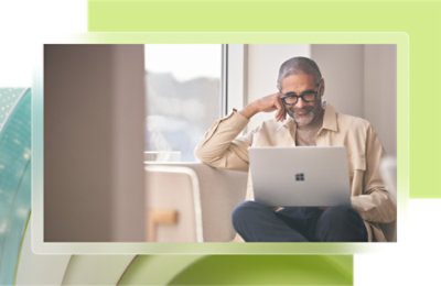 Un homme assis sur une chaise utilisant un ordinateur portable.