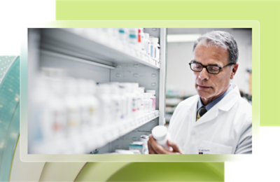 A man in a white coat holding a bottle.