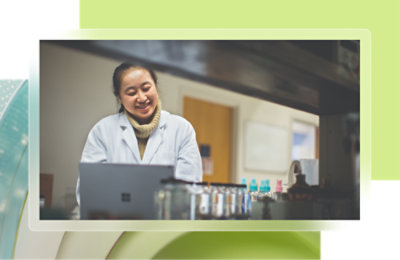 A woman in a lab coat using a laptop.