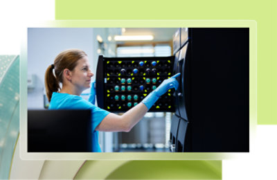 A woman wearing blue gloves and touching a computer screen.