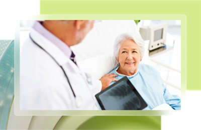 A doctor looking at an old woman in a hospital gown.