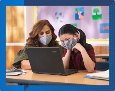 A woman wearing a mask looking at a laptop with a girl wearing a striped fabric mask nearby.