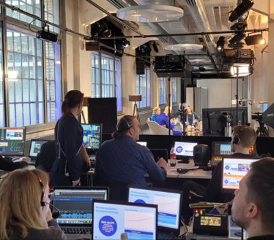 A group of people sitting at a desk with computers.