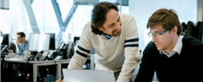 Two people working together at a desk 