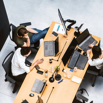 People sitting together, discussing and working with their laptops on the table