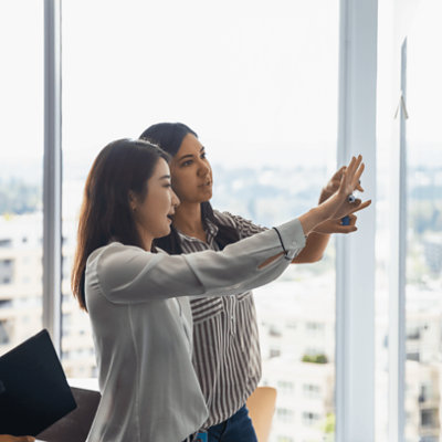 Two women are discussing and holding marker in their hand