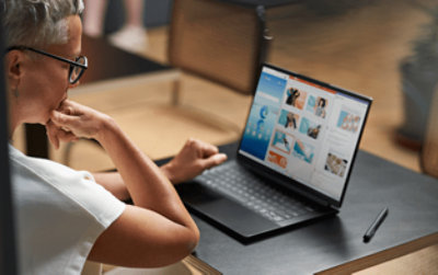 A person looking at his laptop screen placed on the table