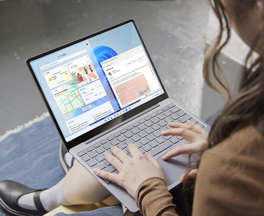 En kvinne bruker Windows 11 på Surface Laptop Go 2.