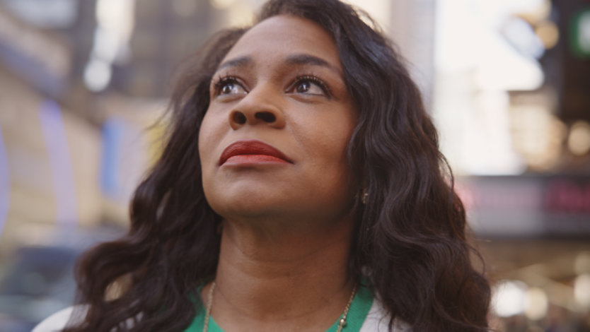 Eine Frau steht vor einem Theater.