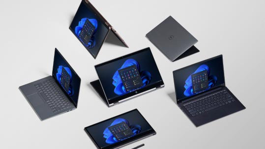 Flere laptops på en grålig baggrund, som er åbne med startskærme vist