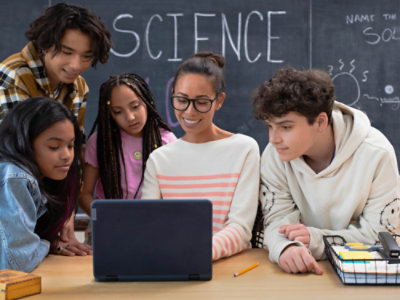 Um grupo de pessoas olhando para um laptop.