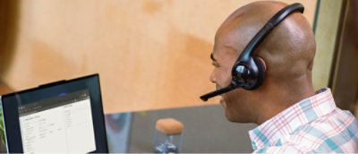 Person wearing a headset looking at a laptop screen with an open document.