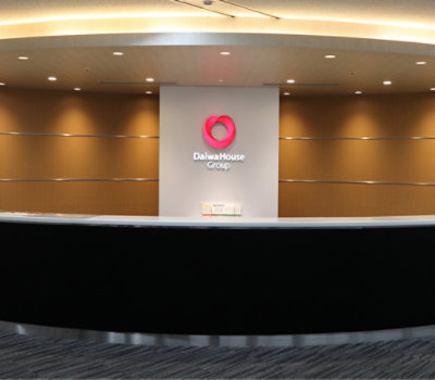 Curved reception desk with the Daiwa House Group logo on the wall behind it.