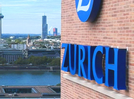 The Zurich Insurance building with a city skyline in the background.
