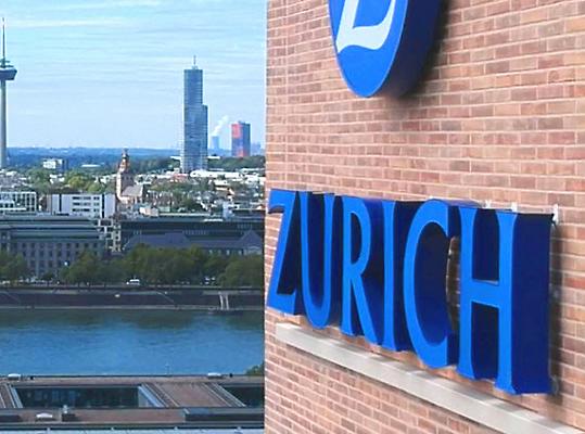 The Zurich Insurance building with a city skyline in the background.