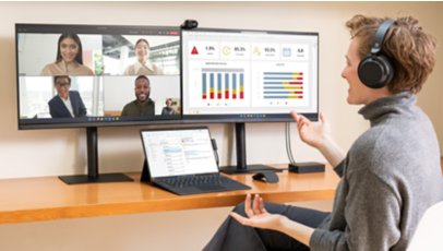A person conducts a meeting and reviews charts on a Surface Pro 9 for Business, hooked up to two external monitors.